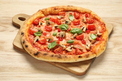 Photo of Delicious pizza with tomatoes, mushrooms and basil on wooden table, closeup