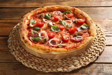 Delicious pizza with salami, tomatoes, mushrooms and basil on wooden table, closeup