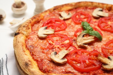 Photo of Delicious pizza with tomatoes, mushrooms and basil on table, closeup