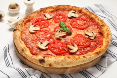 Photo of Delicious pizza with tomatoes, mushrooms and basil on table, closeup