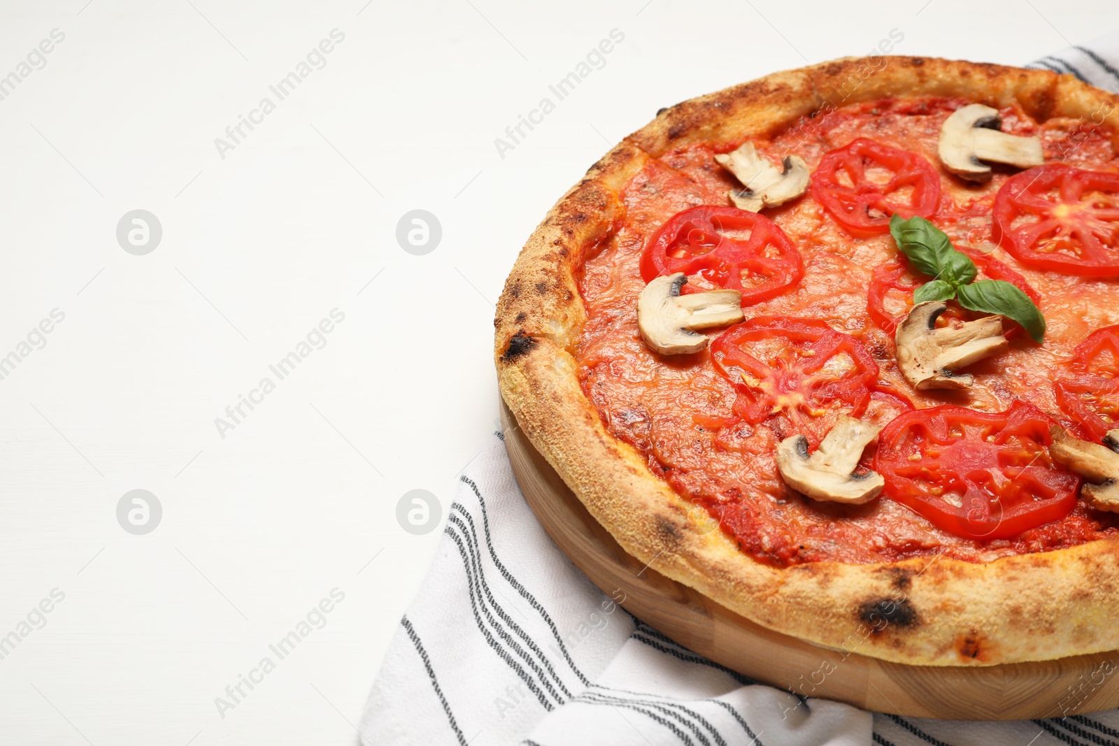 Photo of Delicious pizza with tomatoes, mushrooms and basil on white wooden table, closeup. Space for text