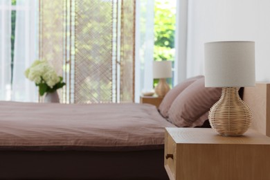 Photo of Stylish bedroom interior with bedside table, lamp and bed