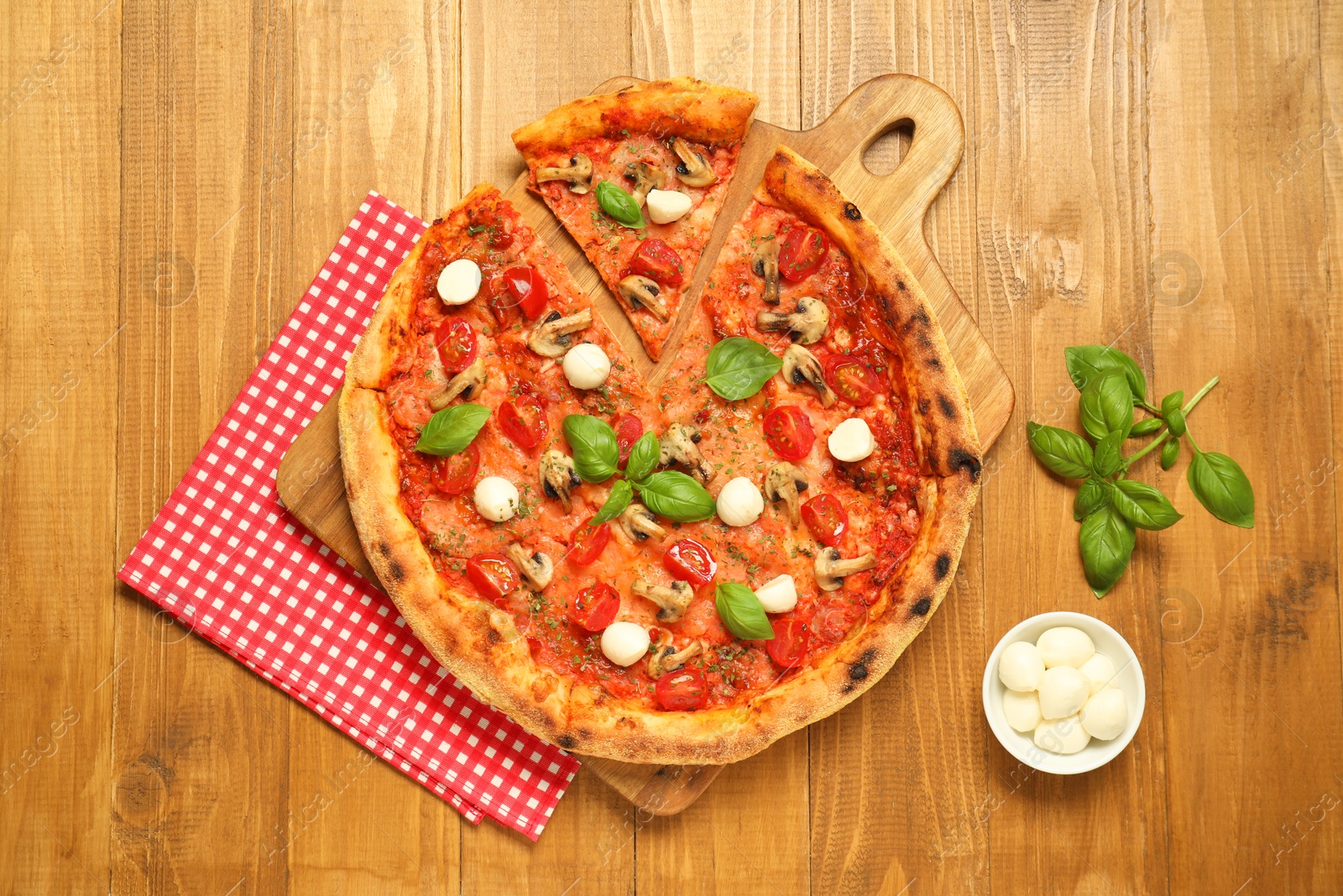 Photo of Tasty pizza with basil, mushrooms, mozzarella and tomato on wooden table, flat lay