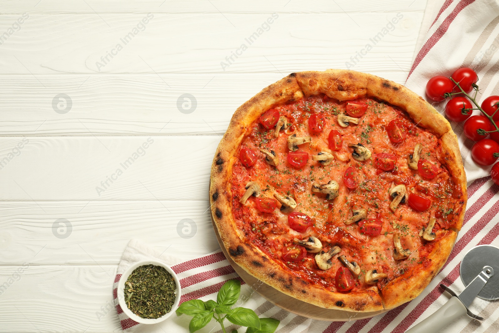 Photo of Tasty pizza with mushrooms, herbs and tomato on white wooden table, top view. Space for text