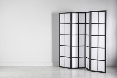 One folding screen near white wall indoors, space for text