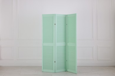 Photo of One folding screen near white wall indoors. Interior element