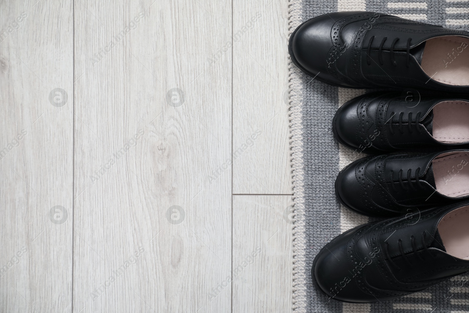 Photo of Big and small shoes on floor, flat lay. Space for text