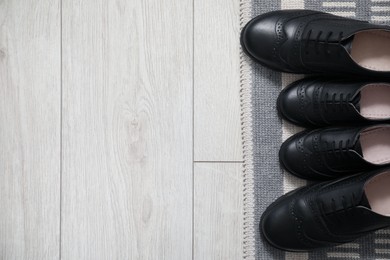 Photo of Big and small shoes on floor, flat lay. Space for text