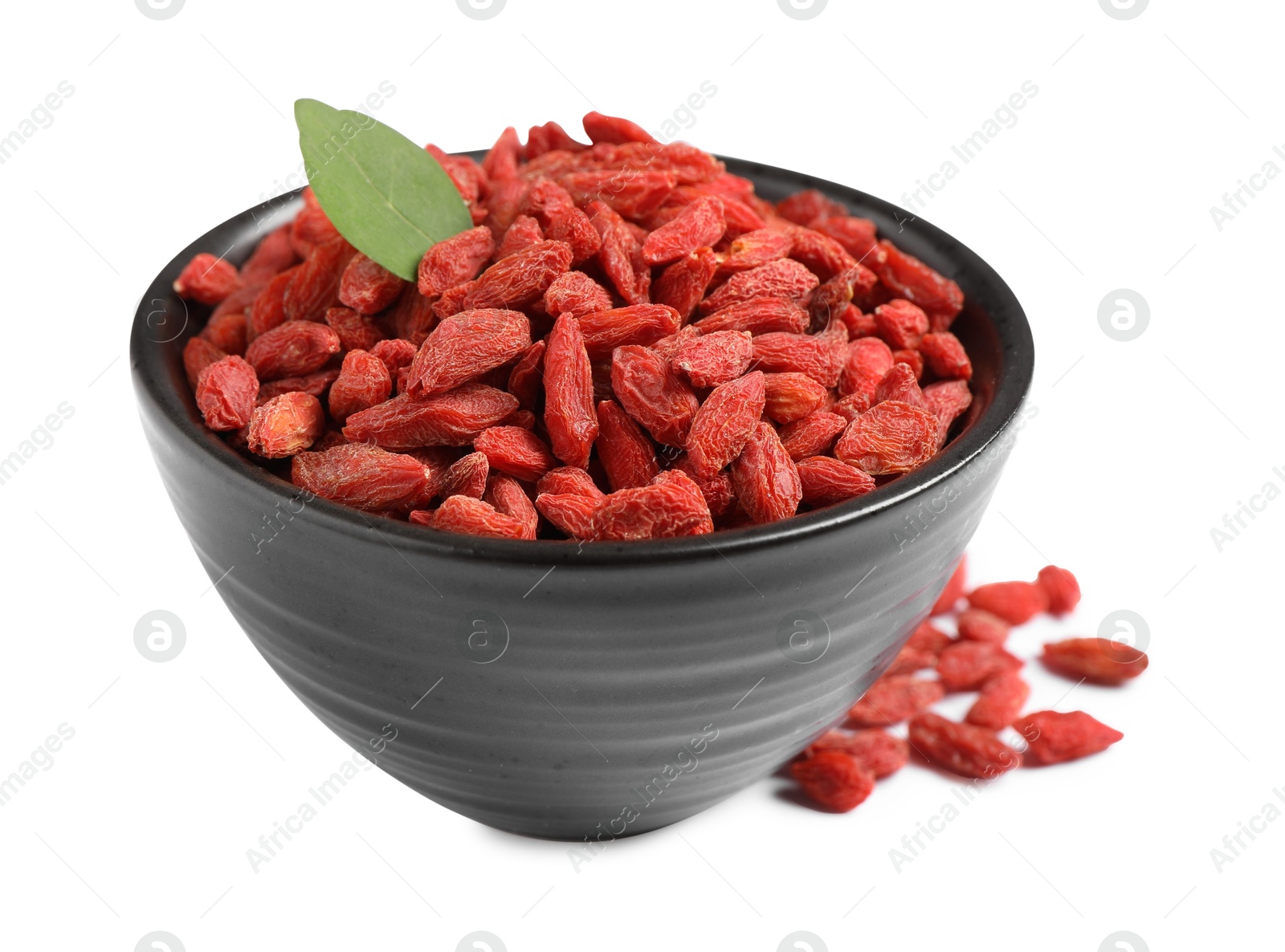 Photo of Dried goji berries in bowl and leaf isolated on white