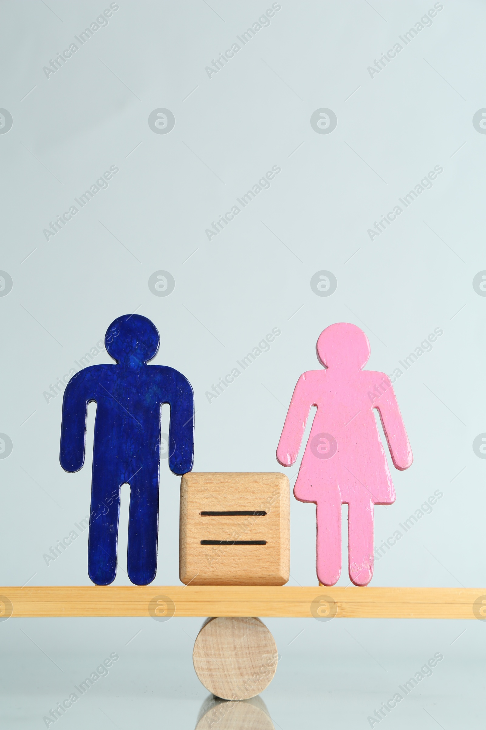 Photo of Gender equality concept. Male and female figures on scales against light background