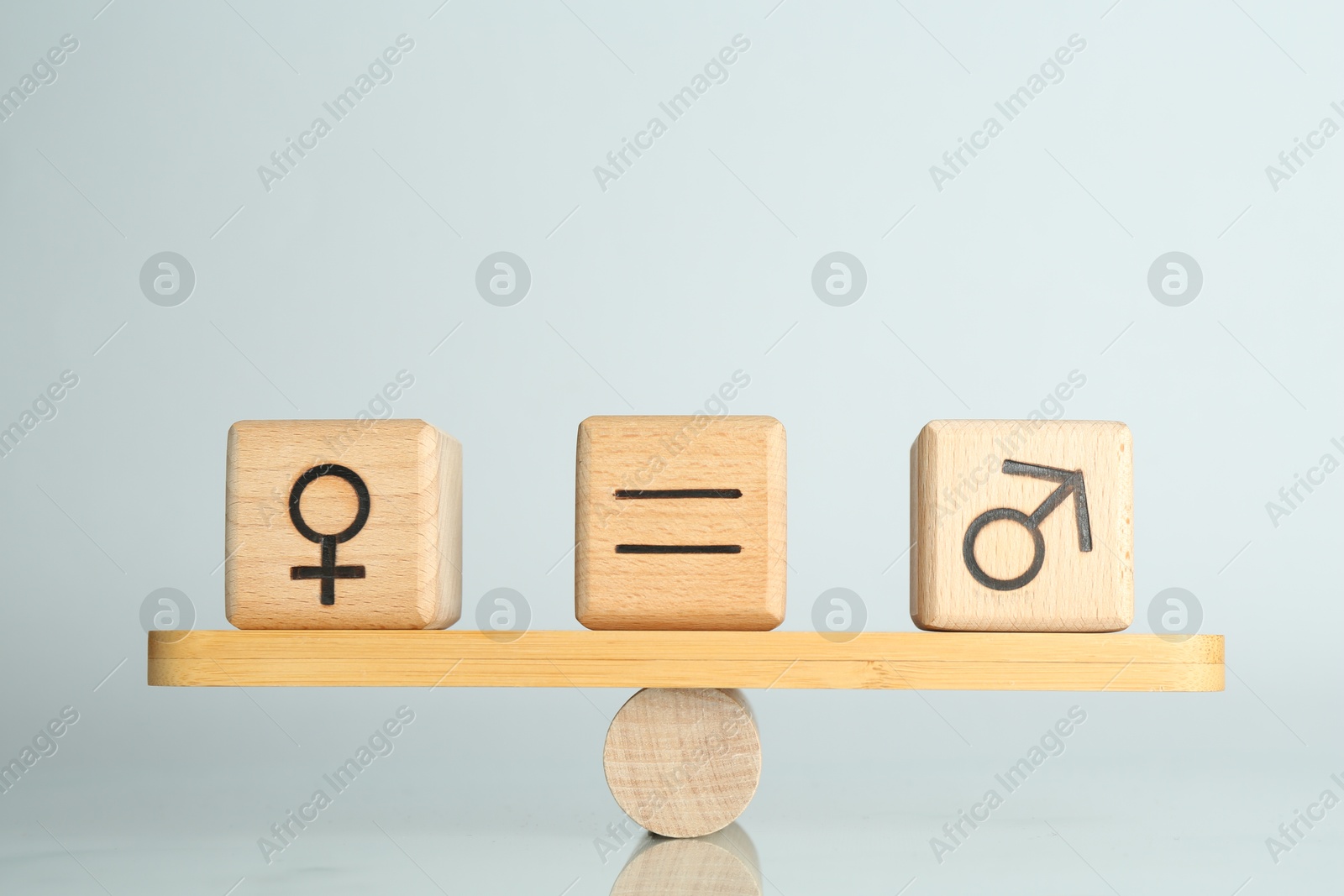 Photo of Gender equality concept. Cubes with male and female symbols on scales against light background