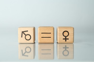 Photo of Gender equality concept. Cubes with male and female symbols on light background