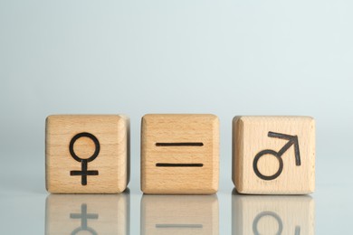 Photo of Gender equality concept. Cubes with male and female symbols on light background