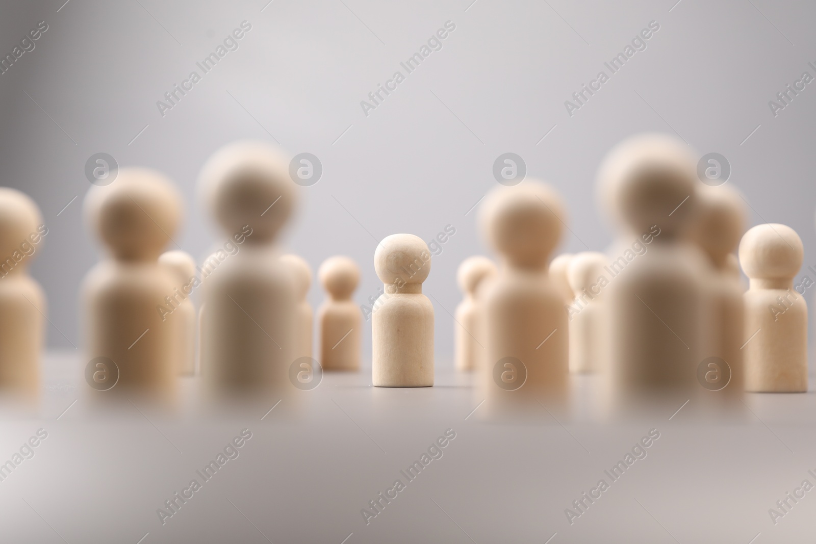 Photo of Loneliness concept. Human figure alone among others on light background