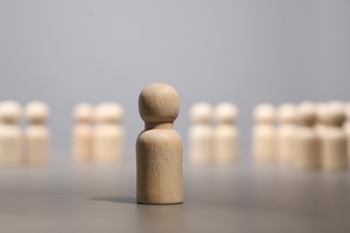 Photo of Loneliness concept. Human figure distant from others on grey background