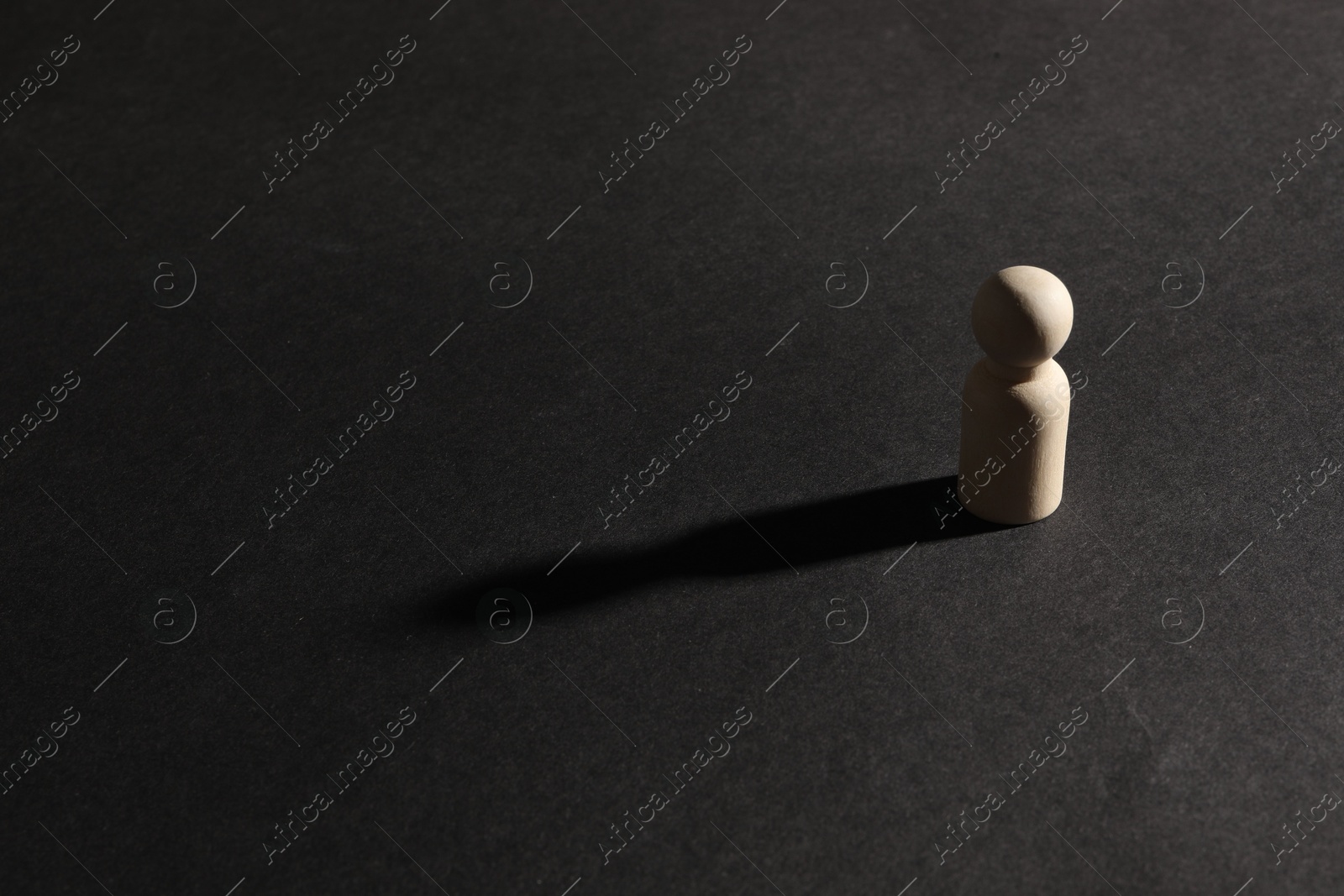 Photo of Loneliness concept. Human figure alone on black background. Space for text