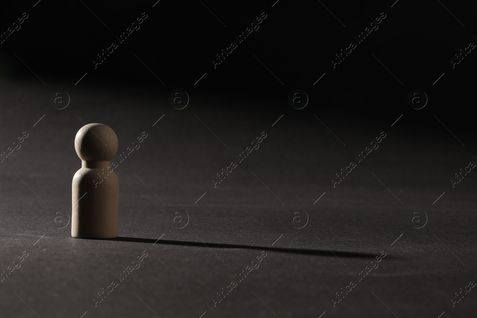 Photo of Loneliness concept. Human figure alone on black background. Space for text