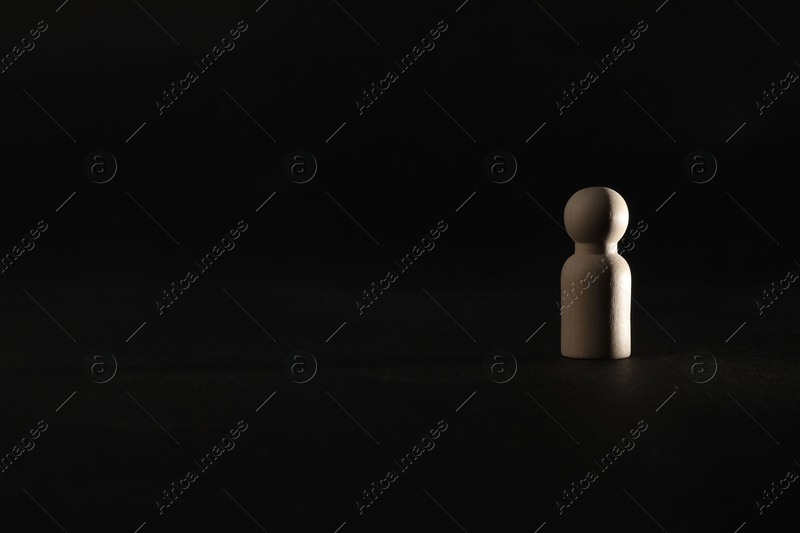 Photo of Loneliness concept. Human figure alone on black background. Space for text