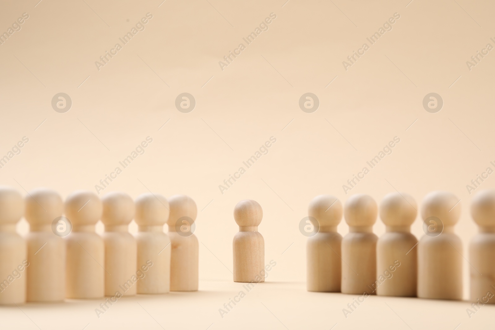 Photo of Loneliness concept. Human figure alone among others on beige background