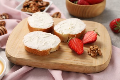 Photo of Delicious bruschettas with ricotta cheese, strawberries and walnuts on table, closeup