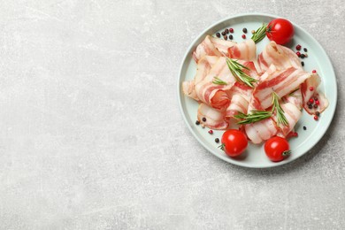 Photo of Slices of raw bacon, spices and tomatoes on light grey table, top view. Space for text