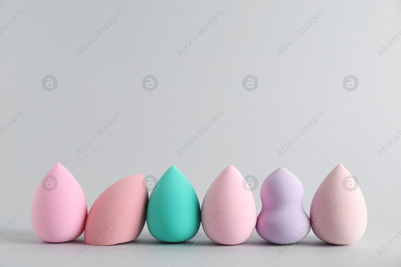 Photo of Many makeup sponges on light grey background