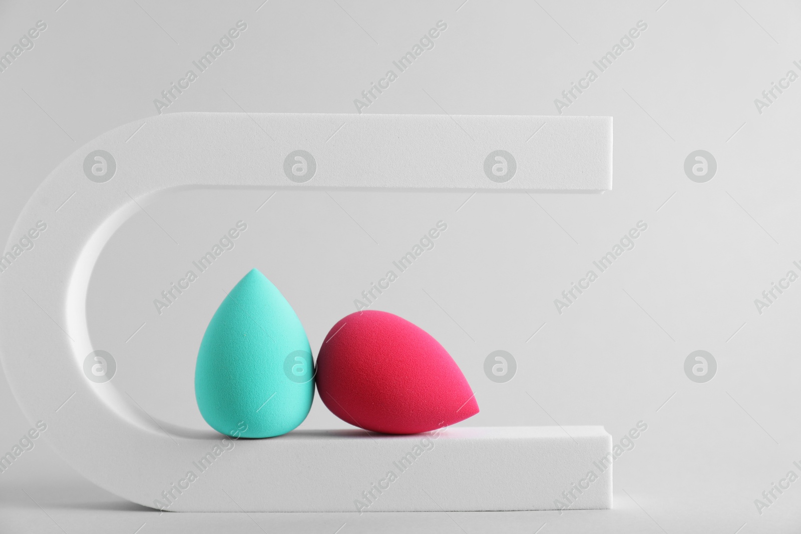 Photo of Stylish presentation of makeup sponges on light grey background