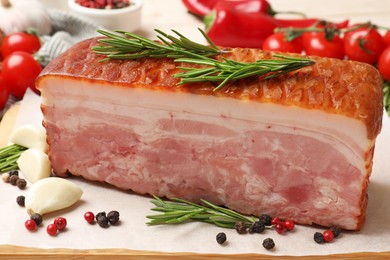 Photo of Piece of raw bacon with spices and cherry tomatoes on wooden table, closeup