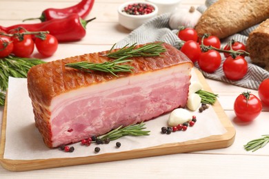 Photo of Piece of raw bacon with spices and cherry tomatoes on white wooden table