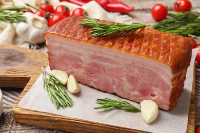 Photo of Piece of raw bacon with spices and cherry tomatoes on wooden table, closeup