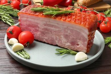 Photo of Piece of raw bacon with spices and cherry tomatoes on wooden table, closeup