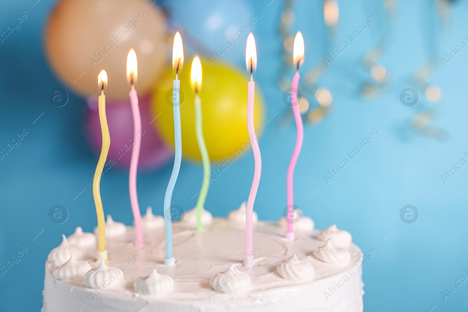 Photo of Tasty Birthday cake with burning candles against light blue background, closeup