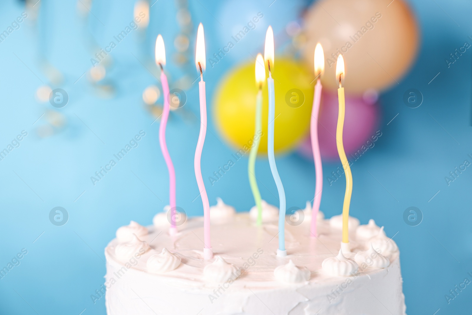 Photo of Tasty Birthday cake with burning candles against light blue background, closeup