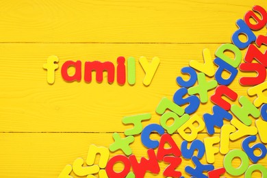 Word Family made of magnetic letters on yellow wooden background, flat lay. Learning alphabet