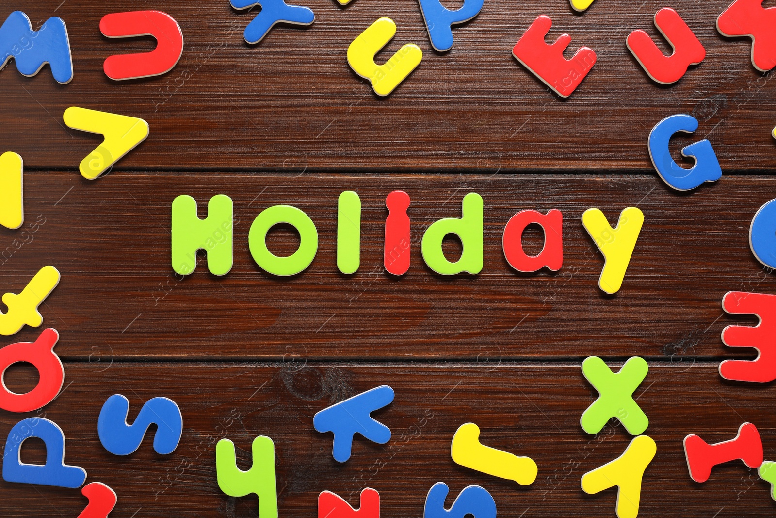 Photo of Word Holiday made of magnetic letters on wooden background, flat lay. Learning alphabet