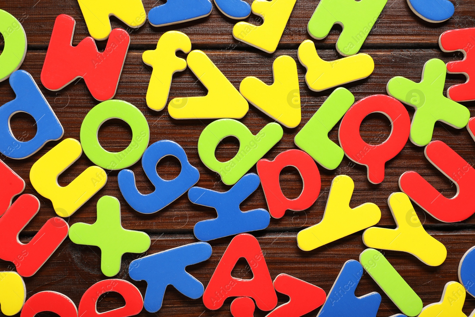 Photo of Magnetic letters on wooden background, flat lay. Learning alphabet