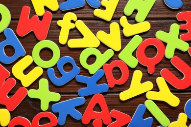 Magnetic letters on wooden background, flat lay. Learning alphabet