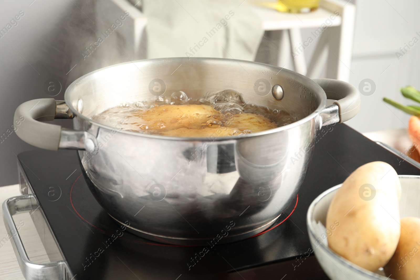 Photo of Boiling potatoes in metal pot on stove