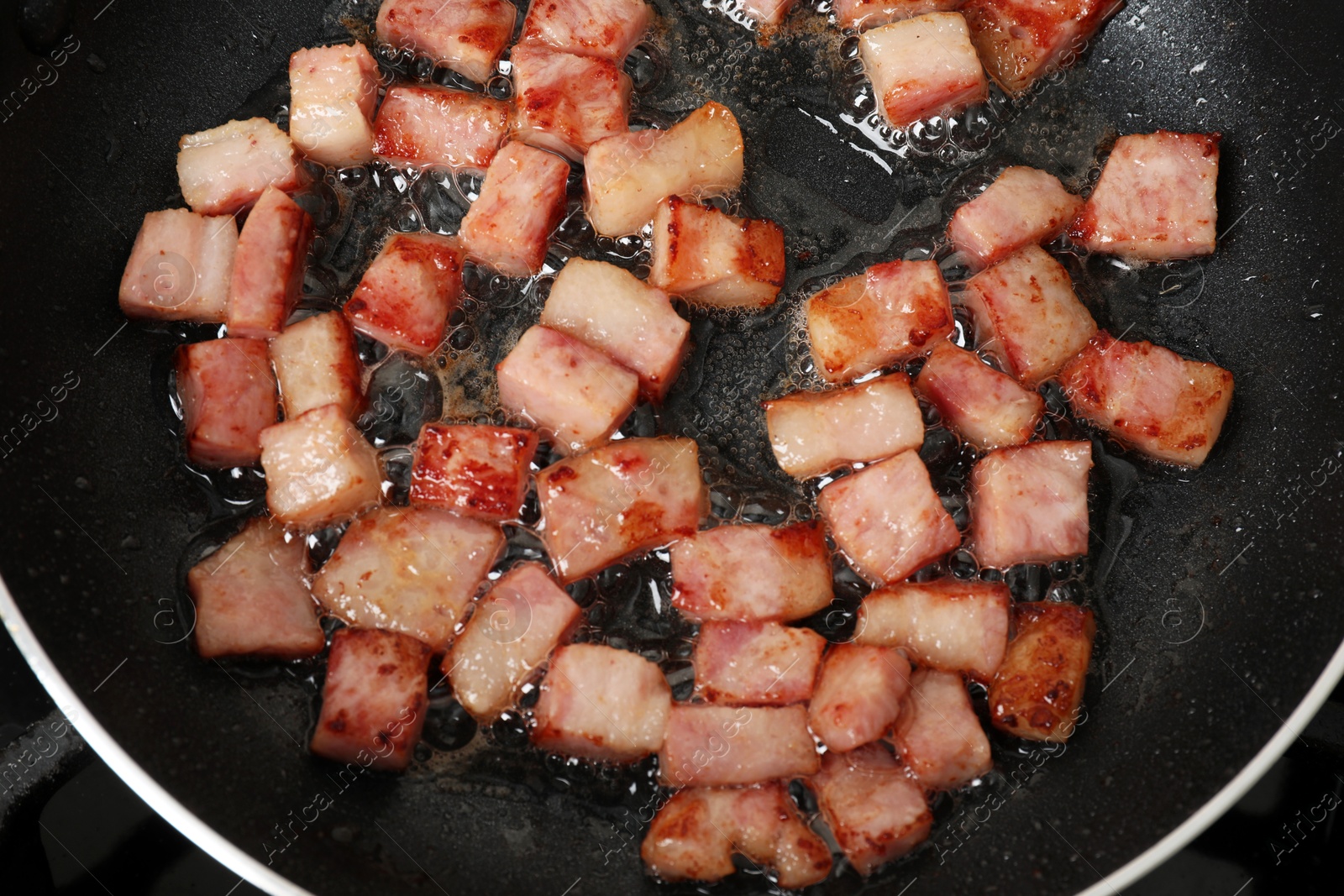 Photo of Pieces of bacon frying in pan, top view