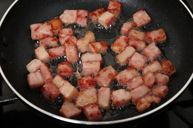 Pieces of bacon frying in pan, closeup