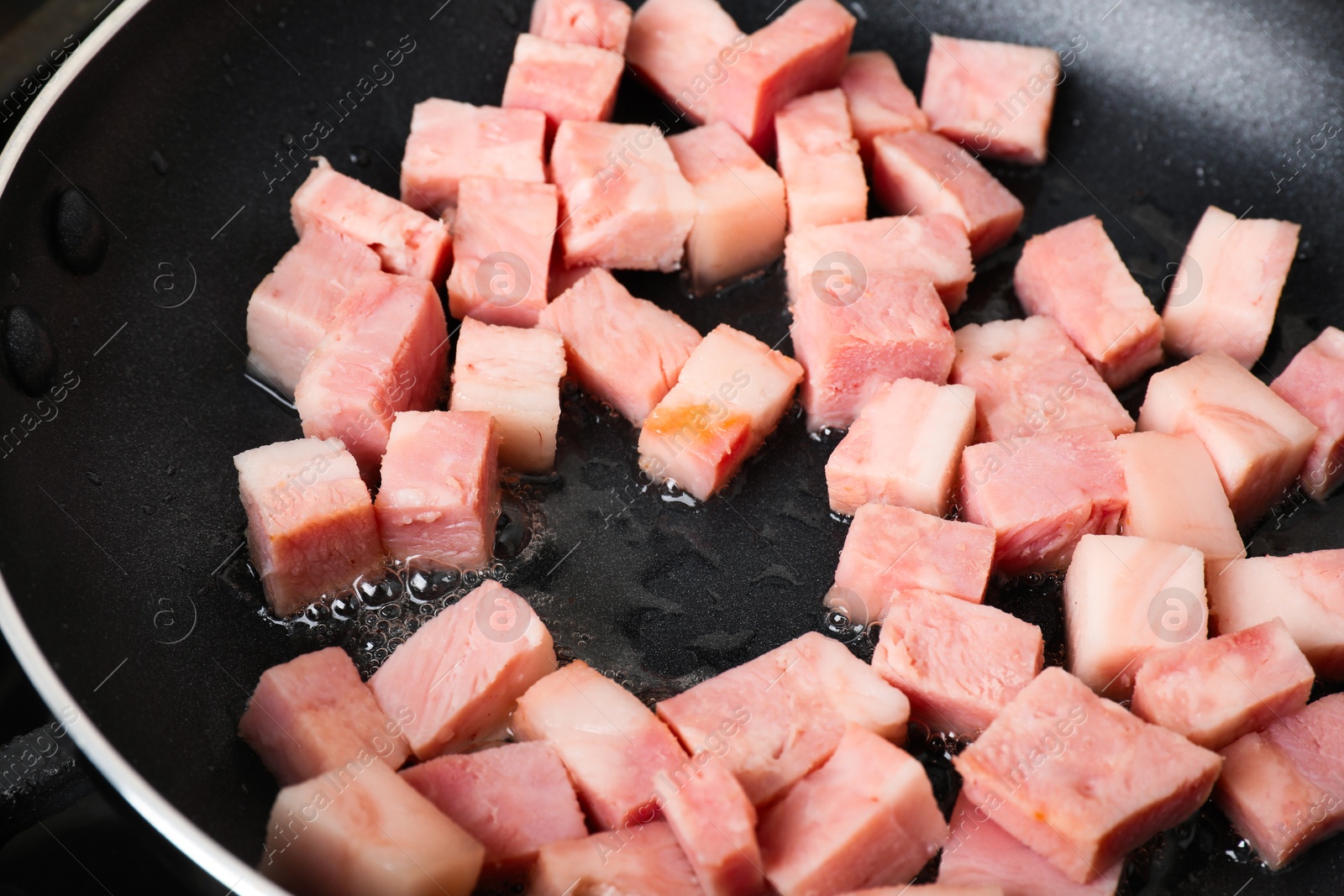 Photo of Pieces of bacon frying in pan, closeup