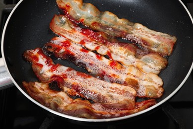 Photo of Slices of bacon frying in pan, closeup