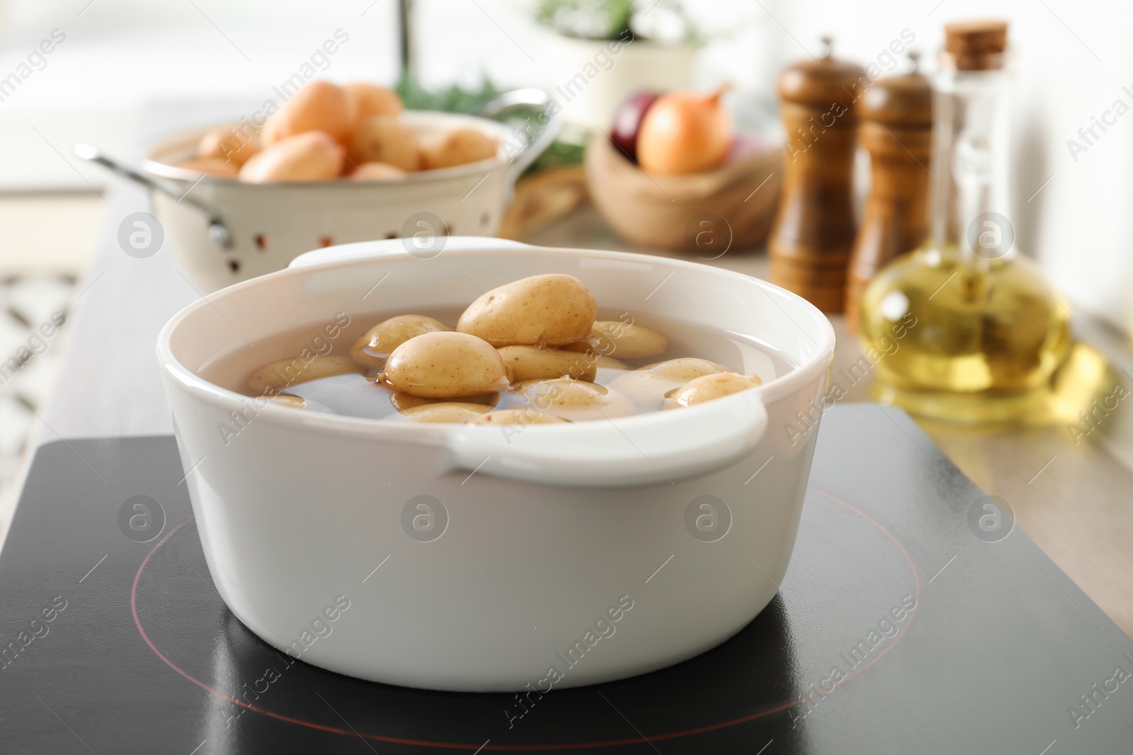 Photo of Boiling potatoes in pot on stove in kitchen