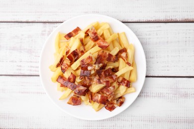 Photo of Delicious French fries with slices of bacon on wooden rustic table, top view