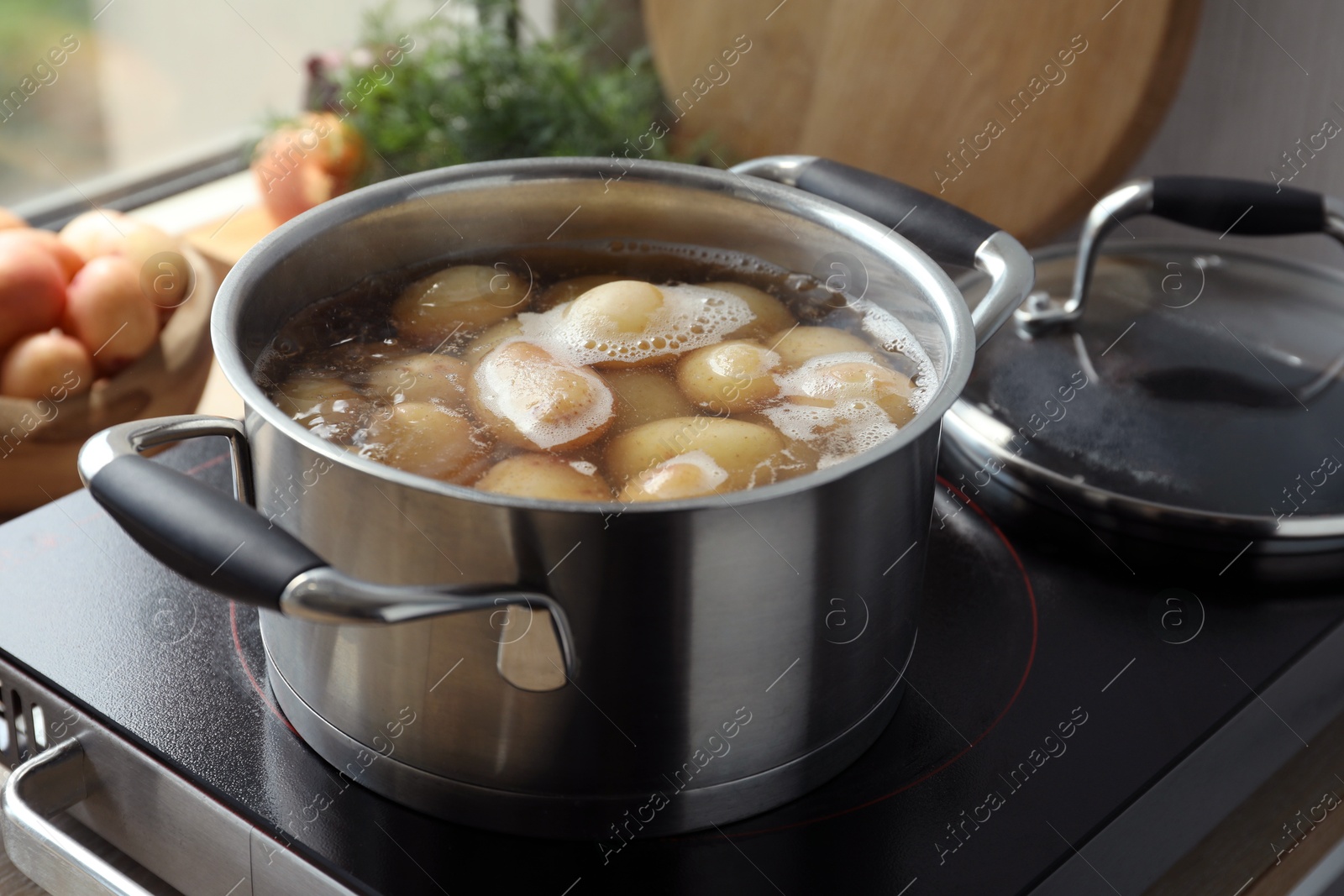 Photo of Boiling potatoes in pot on stove in kitchen