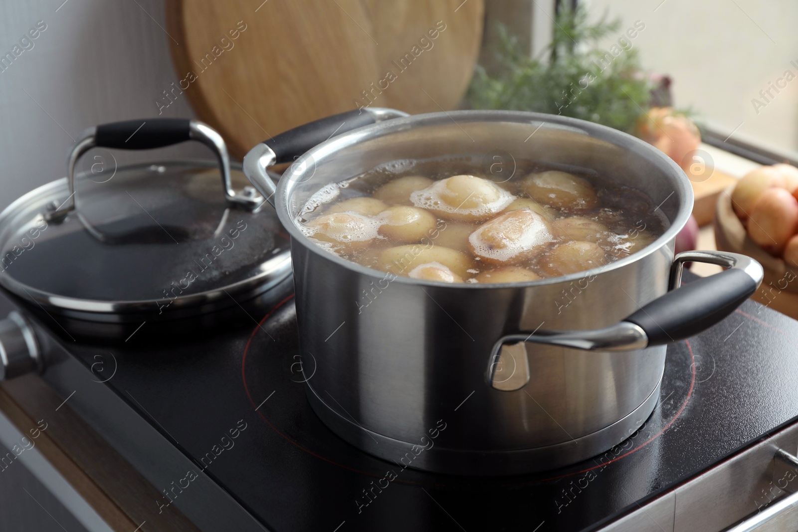 Photo of Boiling potatoes in pot on stove in kitchen