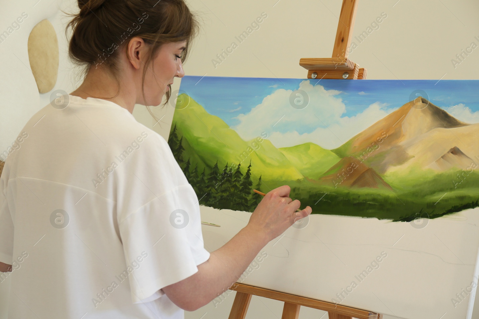 Photo of Woman drawing landscape with brush in studio