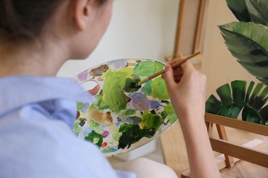 Photo of Woman with brush drawing picture in studio, closeup