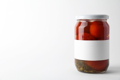 Tasty pickled tomatoes in jar on light background. Space for text