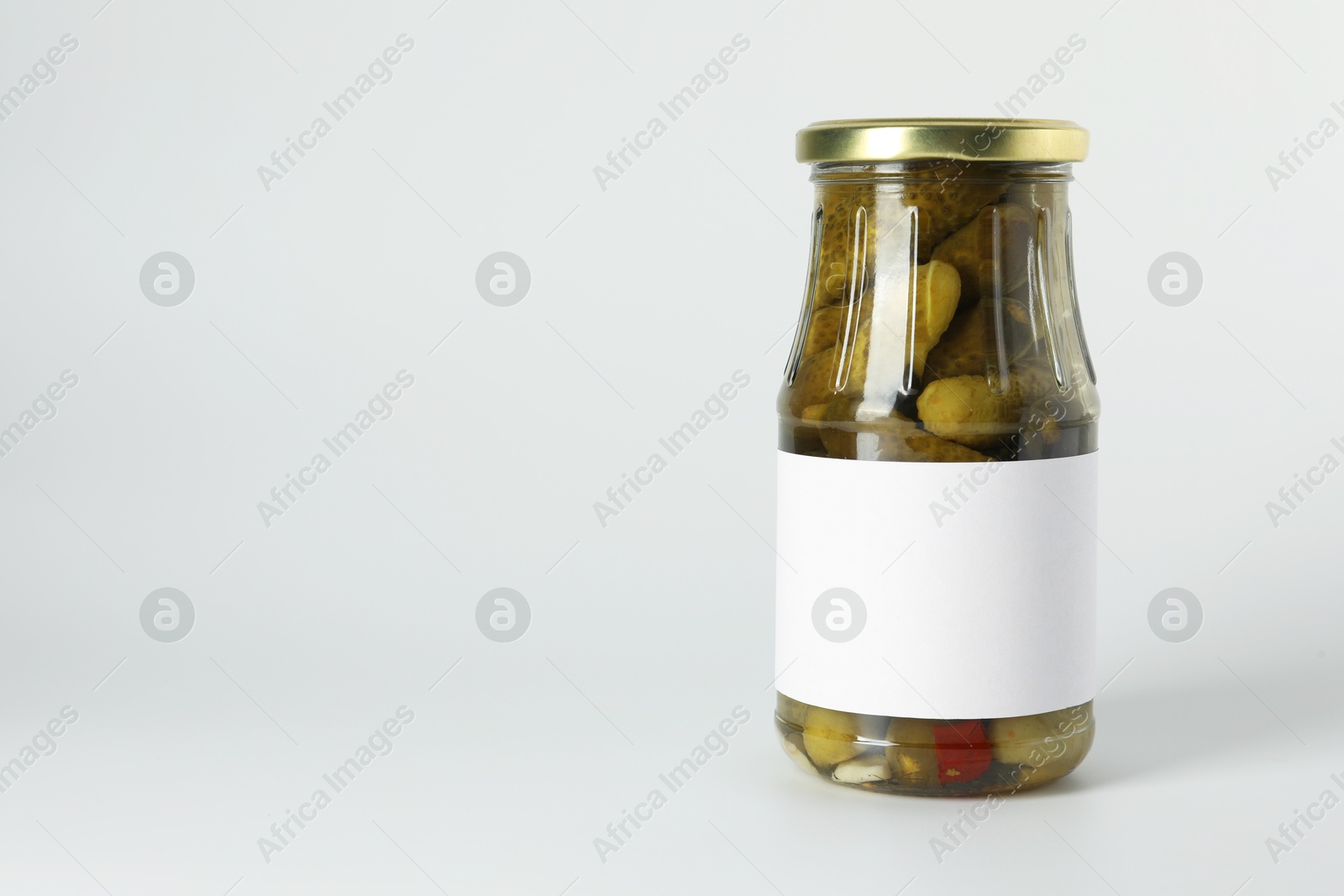 Photo of Pickled cucumbers in jar on light background. Space for text